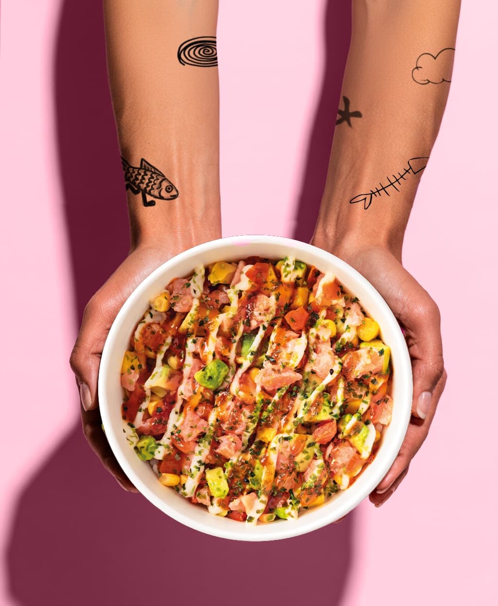 Two hands holding a Made To Chill salmon poké bowl